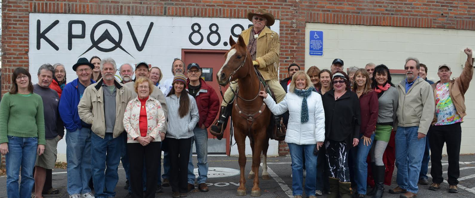 KPOV Community Radio staff and volunteers gather in front of the station