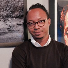 Stephan Herrera in front of a wall of pictures